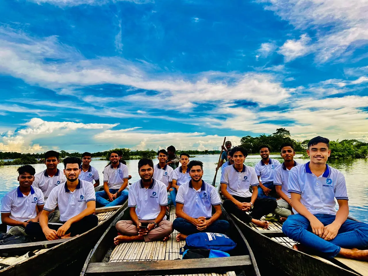 The team sitting in boats under a blue sky on a company tour
